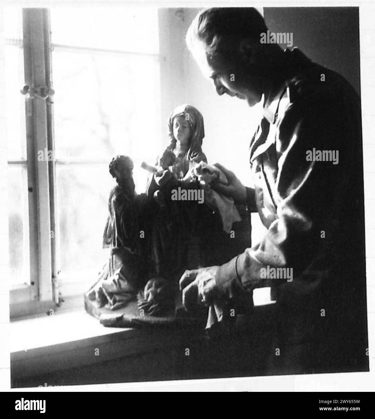 Il capitano Felix Harboard, ex conservatore di Lord Bute, supervisiona monumenti e oggetti storici a Kleve, esaminando una scultura della Vergine Maria dal grande altare sotto la supervisione del 21st Army Group dell'esercito britannico. Foto Stock