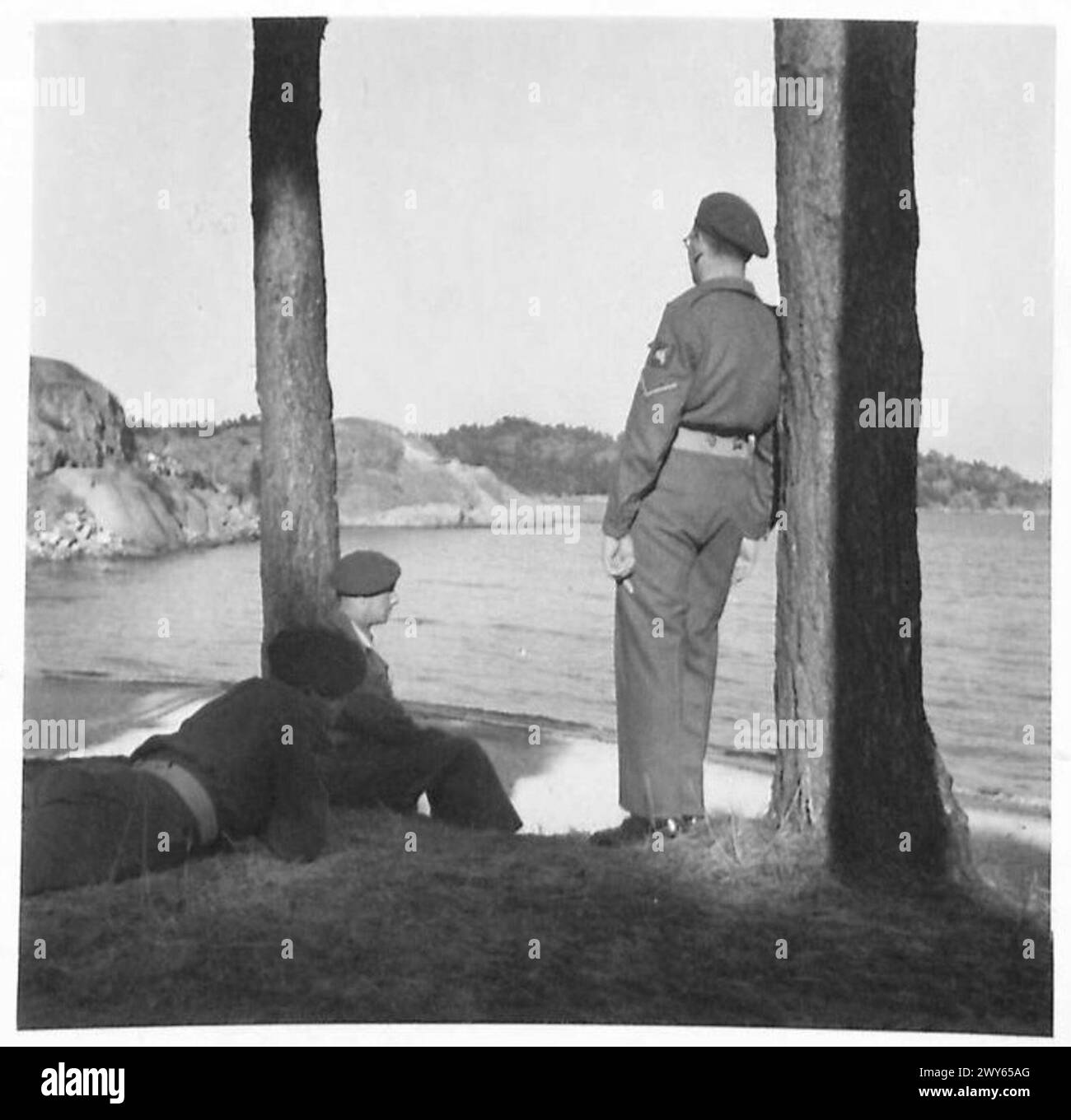 Tre membri della 1st British Airborne Division, noti come 'Red Devils', osservano il paesaggio al campo vacanze di Fevik, in Norvegia, durante la serata. Foto Stock