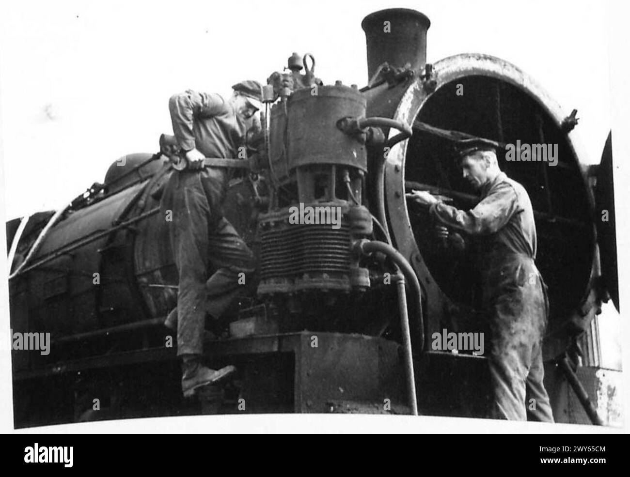 L/Sgt. W. Barrow e L/Sgt. A. Pitchford ripara il sistema Westinghouse di un motore americano presso il Caen Railway Centre, precedentemente utilizzato dalla LPTB, LNER, e successivamente rilevato dalle Ferrovie francesi, documentando i danni provocati dalle bombe e il restauro post-bellico sotto la supervisione dell'esercito britannico. Foto Stock