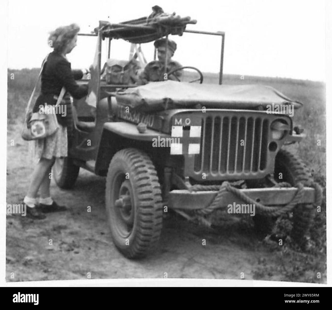 UFFICIALE MEDICO DELL'ESERCITO AGISCE COME MEDICO DEL VILLAGGIO QUANDO è fuori SERVIZIO - dopo una pausa per il cibo il MO e il suo interprete mettono il kit medico nella Jeep e si preparano per ulteriori visite agli abitanti del villaggio. , British Army, 21st Army Group Foto Stock