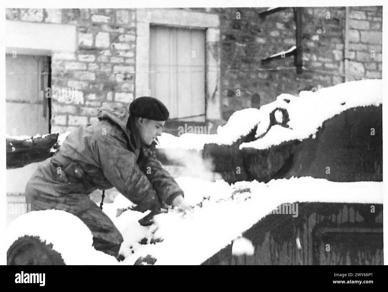 Il Trooper John Edward Davies di Wrexham pulisce la neve da una torretta di carri armati usando una scopa presa in prestito durante le operazioni invernali dell'esercito britannico, il 21st Army Group. Foto Stock
