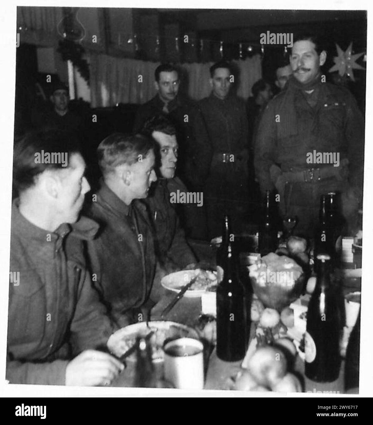 Il colonnello W.A. Waller MC del 1st South Lancashire Regiment si rivolge ai suoi uomini durante una cena di Natale tenutasi presso il monastero di Venray in Olanda, parte del 21st Army Group britannico. Foto Stock