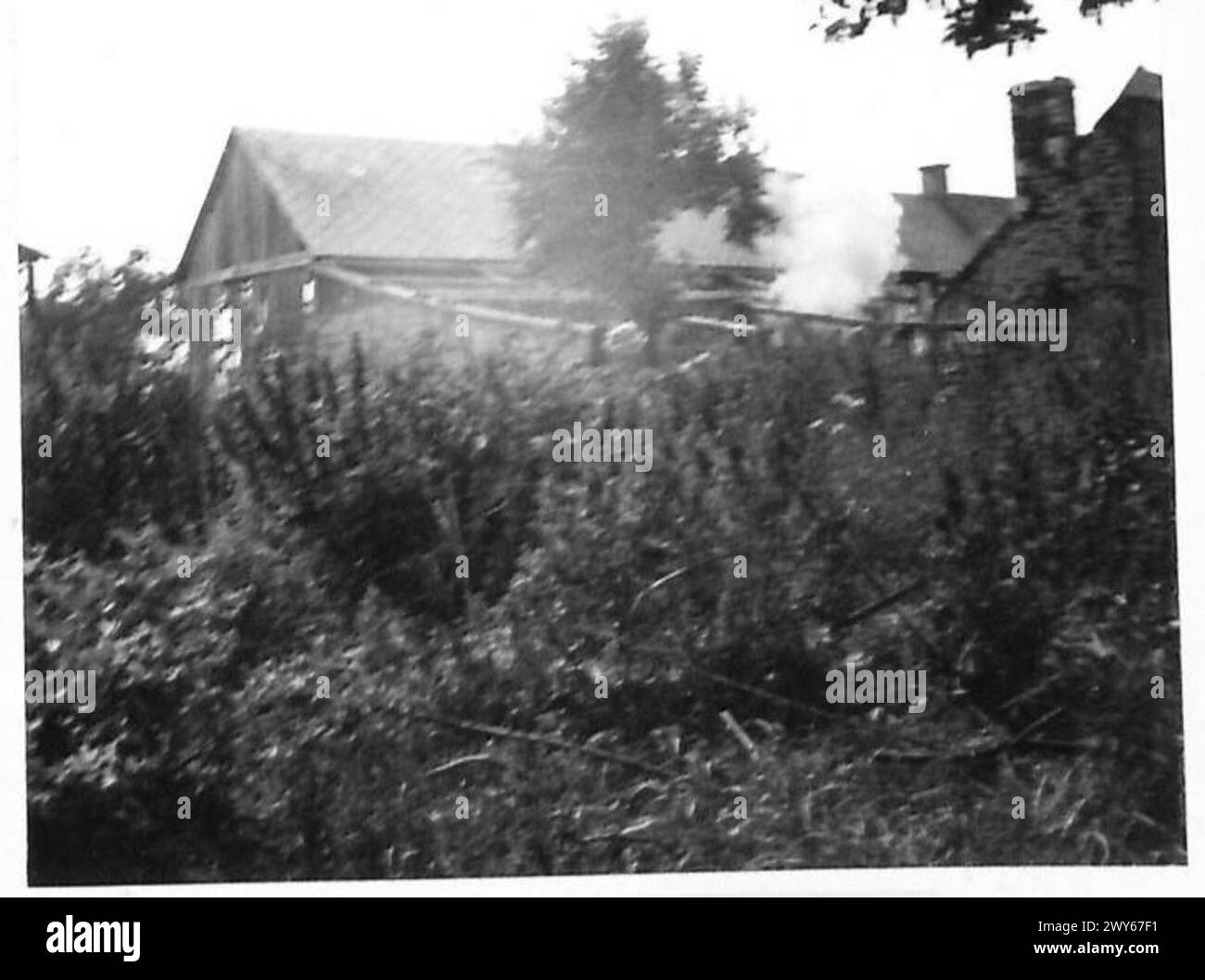 Un gruppo di sgombero di cecchini opera in una fattoria, con una granata che esplode su un edificio durante un'azione militare. Foto Stock