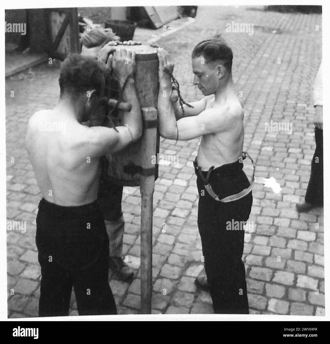 Tre uomini belgi sono assicurati dalle loro armi a una resistenza come parte della tortura inflitta dalle forze tedesche, illustrando i metodi di coercizione e abuso durante l'occupazione, documentati dall'esercito britannico, 21st Army Group. Foto Stock