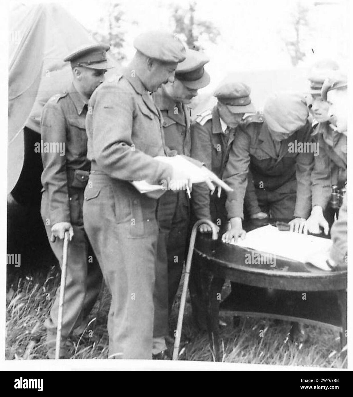 Gli ufficiali britannici e russi tengono una conferenza in un campo di sfollati per pianificare il lavoro della giornata durante la seconda guerra mondiale Foto Stock