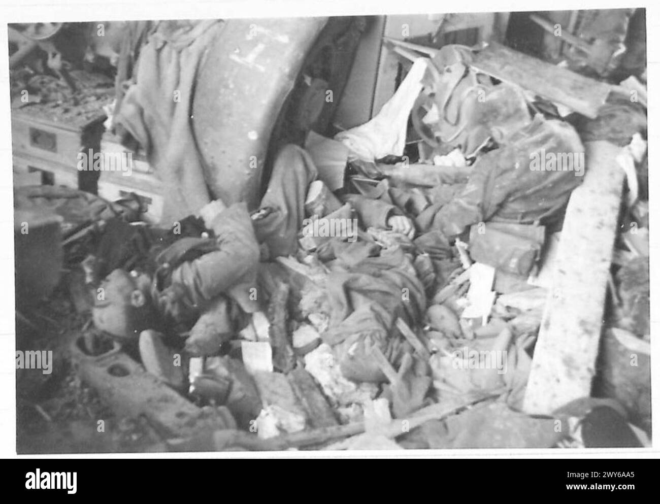 All'interno di un deposito di cannoni tedesco distrutto sull'isola di Walcheren dove era montato un cannone britannico da 3,7 pollici; un soldato tedesco morto detiene un proiettile da 3,7 pollici, contrassegnato dal britannico 1939 R.N. Lodge Hill, TNT filled, British Army, 21st Army Group. Foto Stock