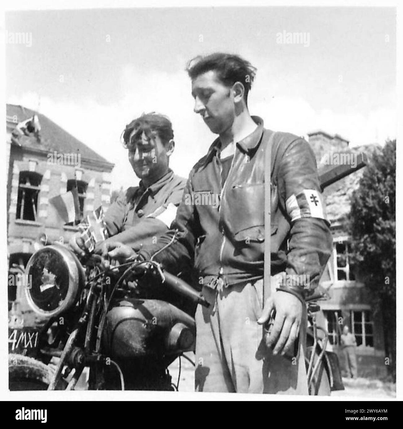 Due membri della resistenza francese libera inchiodano le bandiere alleate su una motocicletta a Putanges dopo la cattura di Futanges ed Écouché da parte delle forze britanniche. Foto Stock