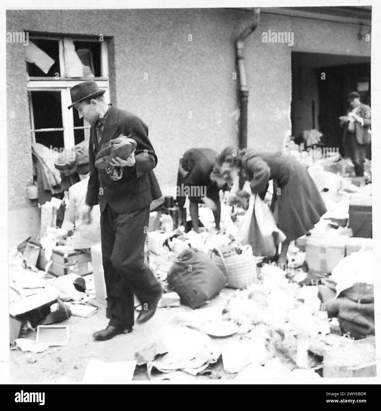 I prigionieri di guerra russi liberati perlustrarono i detriti lasciati dalle forze tedesche in ritirata mentre le truppe britanniche raggiungevano celle. Foto Stock