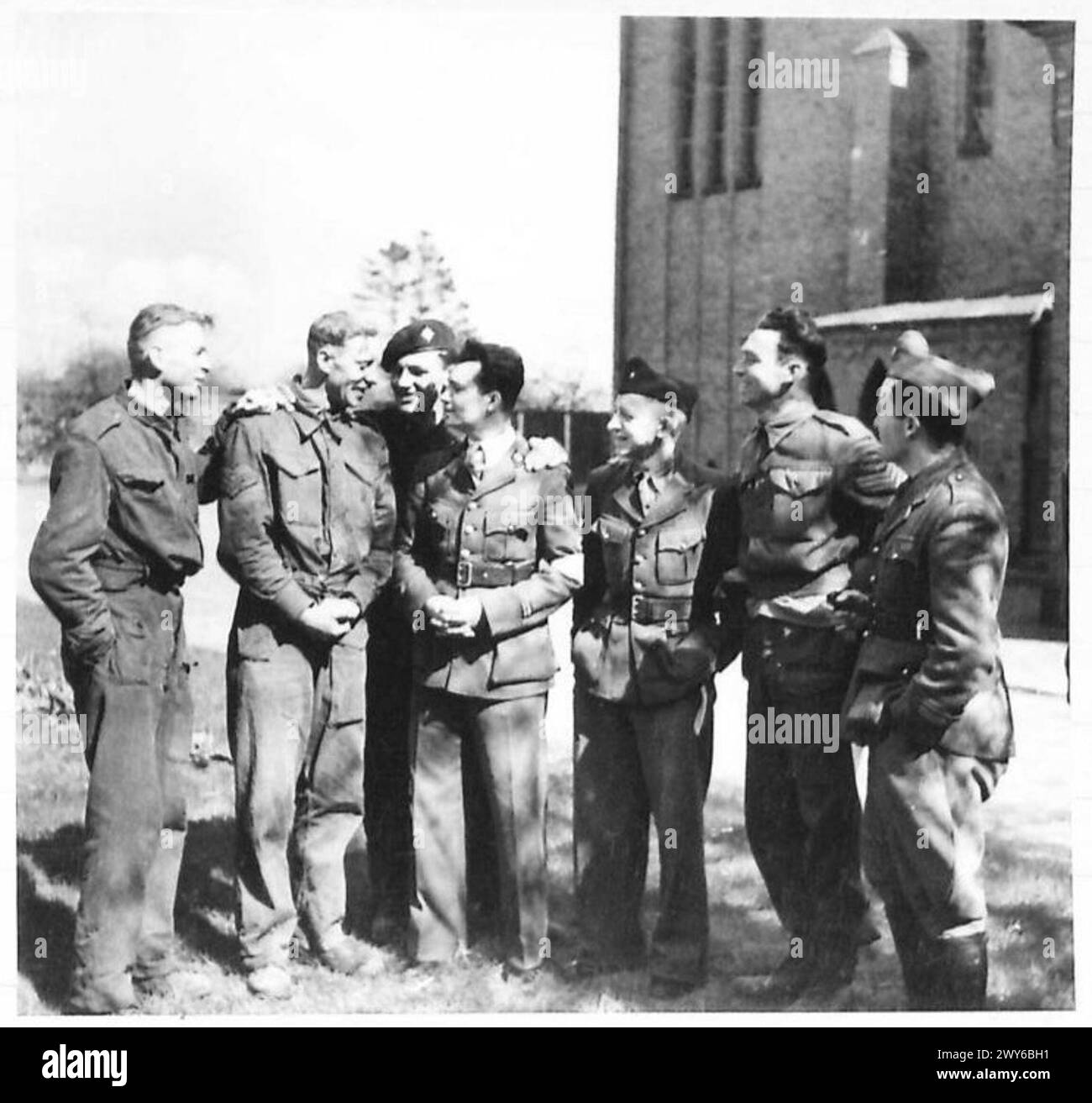 Prigionieri britannici, recentemente liberati, parlano con altri prigionieri alleati, riflettendo l'attività post-liberazione sotto il British Army, 21st Army Group. Foto Stock