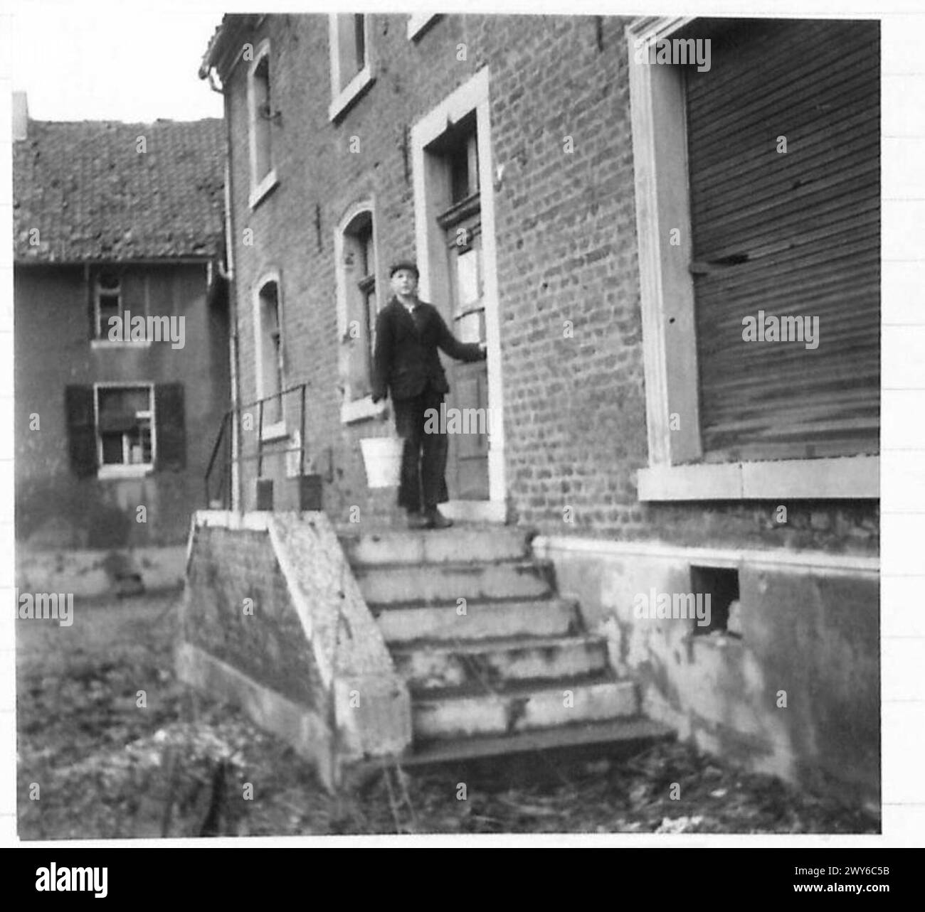 Un tedesco diciassettenne risiede indisturbato in una casa distrutta a Ubach durante l'avanzata ad est di Geilenkirchen da parte dell'esercito britannico, 21st Army Group. Foto Stock