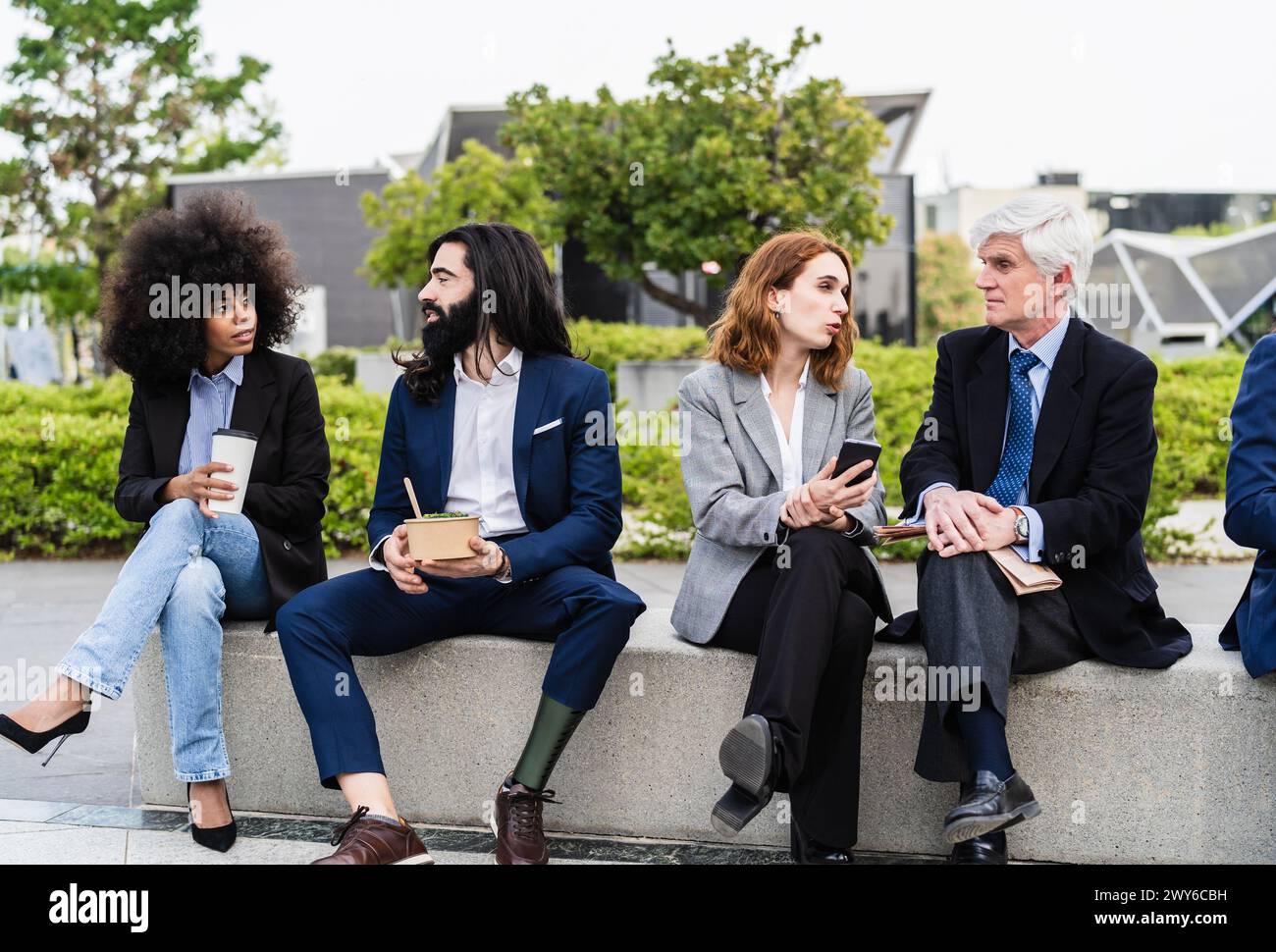 Uomini d'affari multirazziali con età diverse che fanno una pausa pranzo fuori dall'ufficio Foto Stock