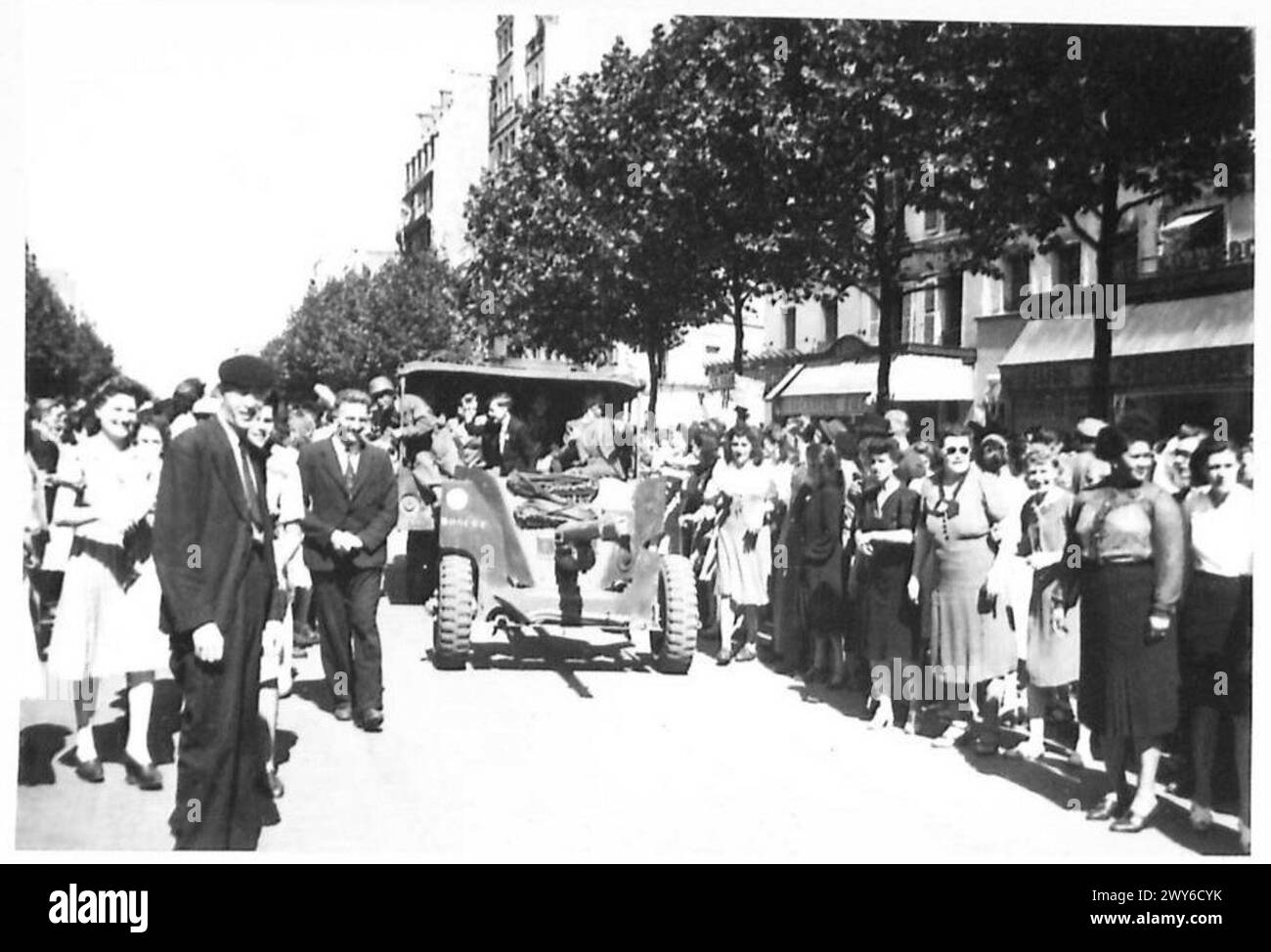 La gente di Parigi si riunisce per le strade per accogliere le truppe britanniche, americane, canadesi e francesi che entrano nella città liberata durante la seconda guerra mondiale, mostrando scene di giubilo e celebrazione. Foto Stock