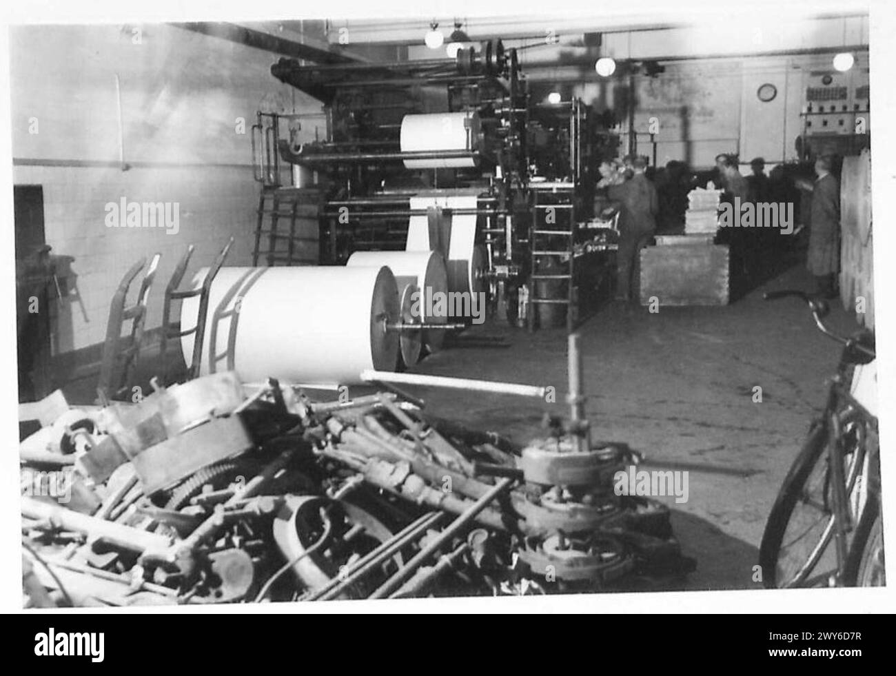 Le rotative stampano un giornale in Germania, con macchinari bruciati visibili in primo piano. Foto Stock