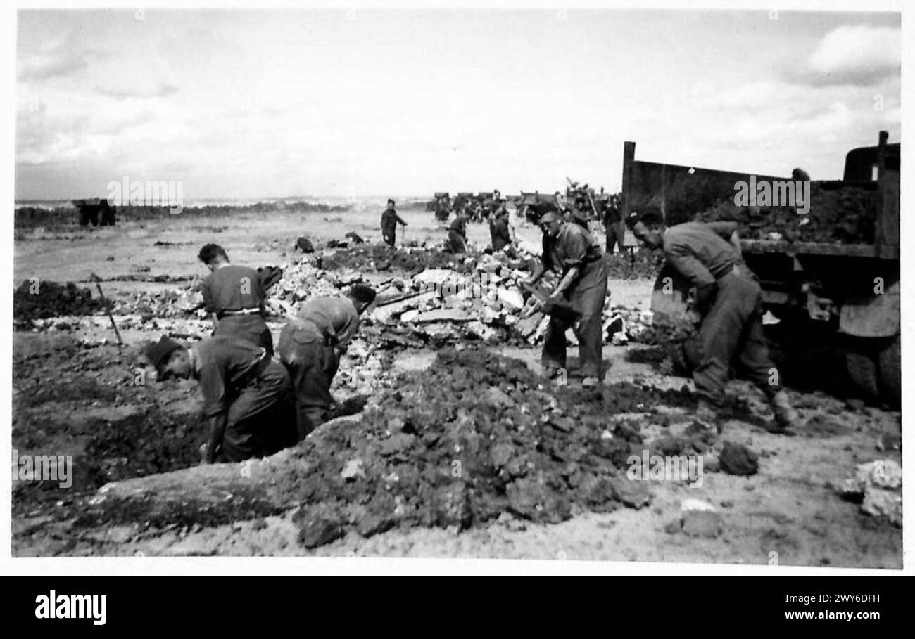 Il personale dell'esercito britannico carica cemento e terra in un camion come parte della ricostruzione dell'aeroporto in Francia, 21st Army Group. Foto Stock