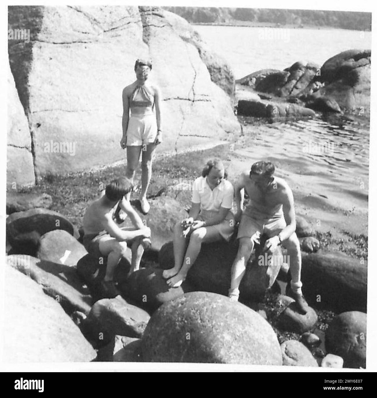 I membri della 1st British Airborne Division, noti come Red Devils, sono ritratti in un campo vacanze a Fevik, Norvegia, interagendo con i civili locali sulla spiaggia. Foto Stock