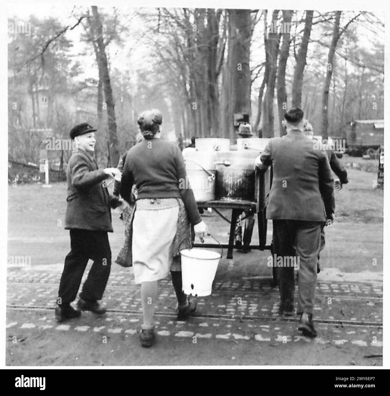 I civili tedeschi raccolgono razioni di cibo sotto la supervisione del governo militare da blocchi e dormitori durante le operazioni del 21st Army Group. Foto Stock