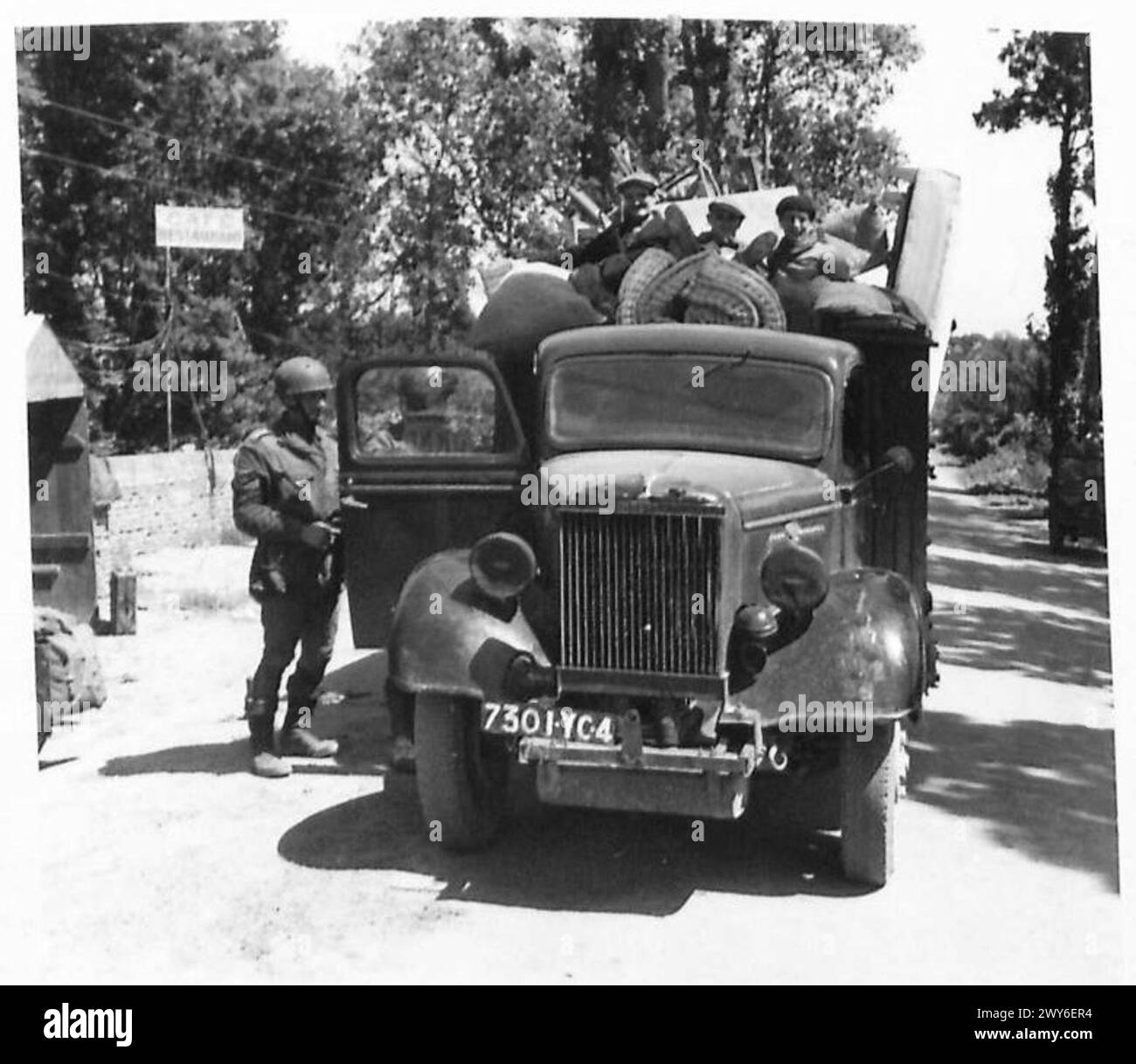 La polizia militare ispeziona un camion che trasporta rifugiati che tenta di attraversare il ponte sul fiume Orne a Benouville. Foto Stock