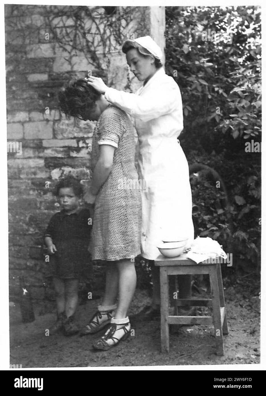 I bambini che arrivano in un campo di transito dopo l'esposizione alla Terra di nessuno vengono lavati e curati dalle infermiere, a seguito della privazione e delle cattive condizioni durante l'occupazione tedesca, come parte delle operazioni dell'esercito britannico. Foto Stock