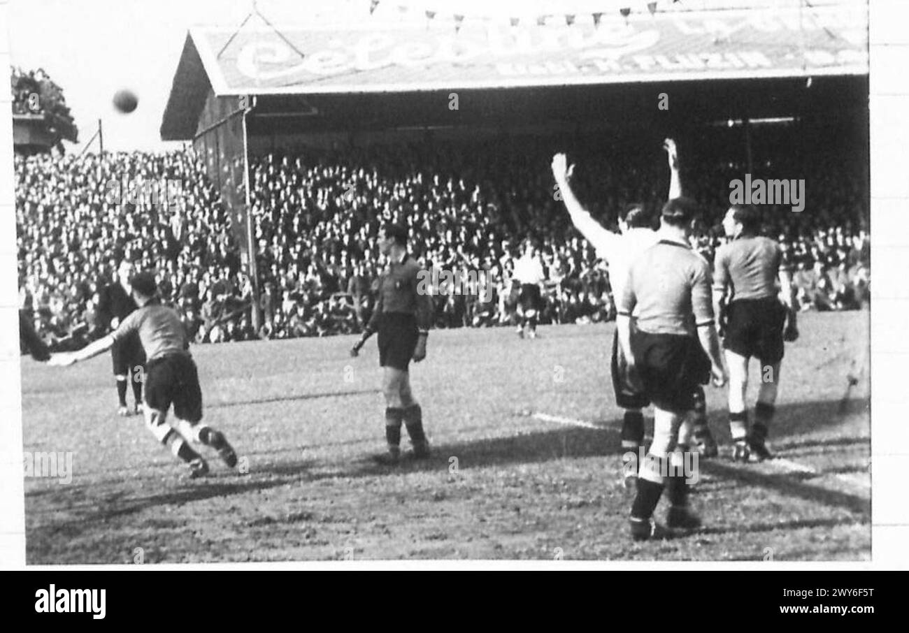 Una partita di calcio si svolge tra squadre britanniche e belghe a Bruxelles, registrata su film durante la presenza dell'esercito britannico. Foto Stock