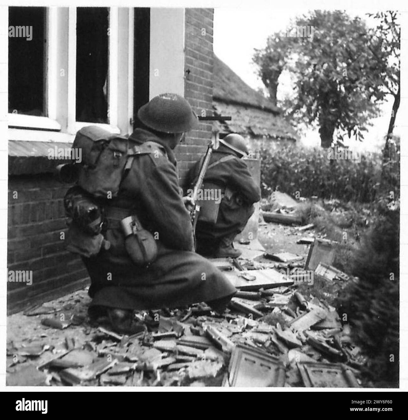 La fanteria delle 1/5 Queen's osservò per cecchini nemici da un angolo di casa a Doornhock durante l'avanzata dell'esercito britannico su Berlicum. Foto Stock