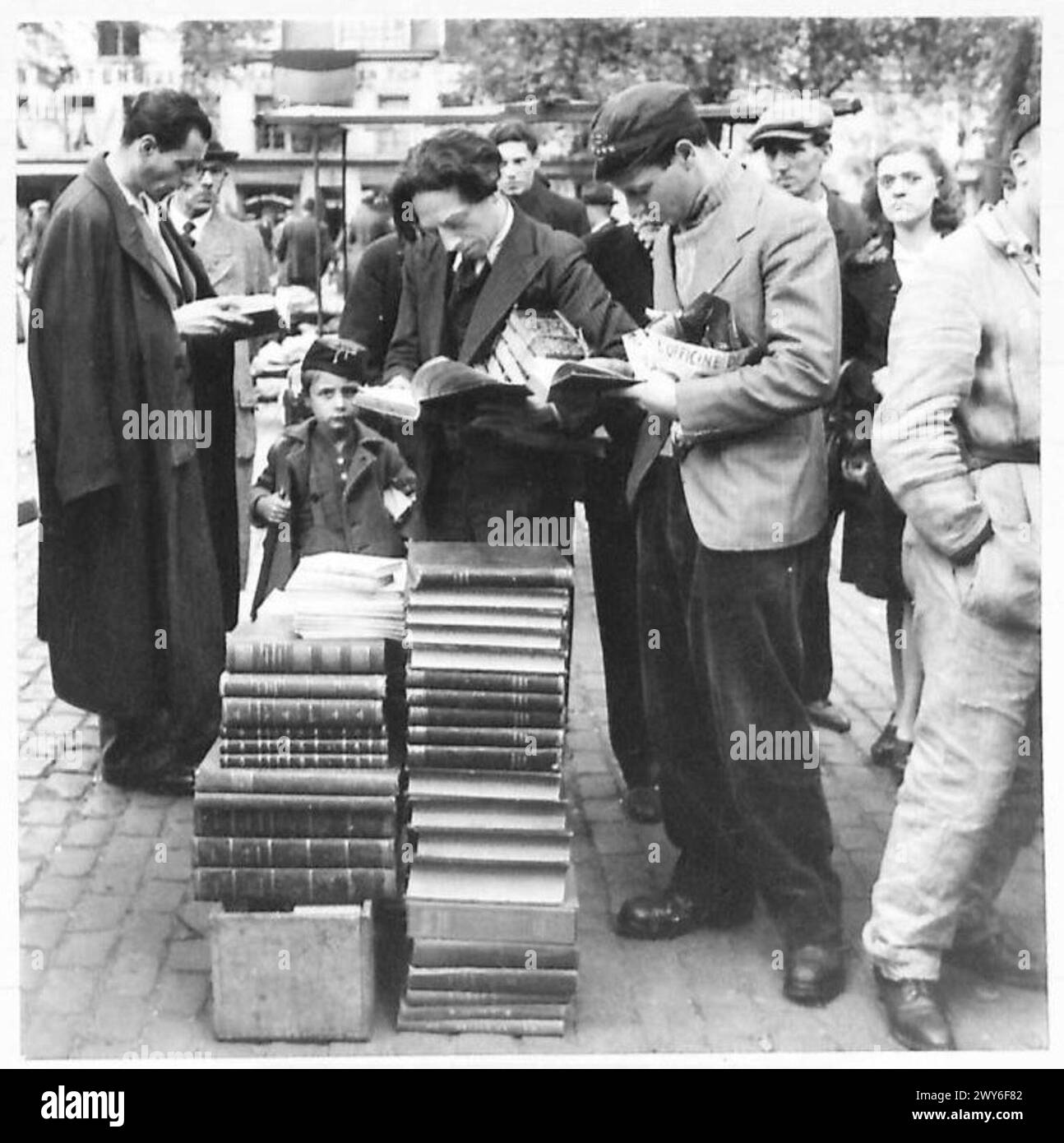 Folle di belgi fanno acquisti in un mercato domenicale mattutino a Bruxelles, comprese le aree in cui il cibo e le forniture venivano distribuite durante l'occupazione tedesca. Foto Stock