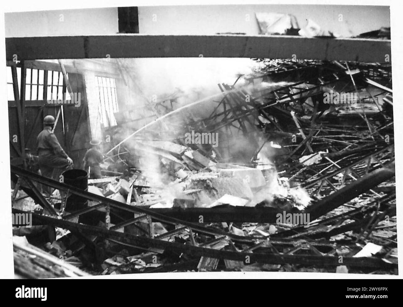 I membri dei vigili del fuoco dell'esercito spinsero un incendio in garage a Caen, documentato dal British Army, 21st Army Group. Foto Stock