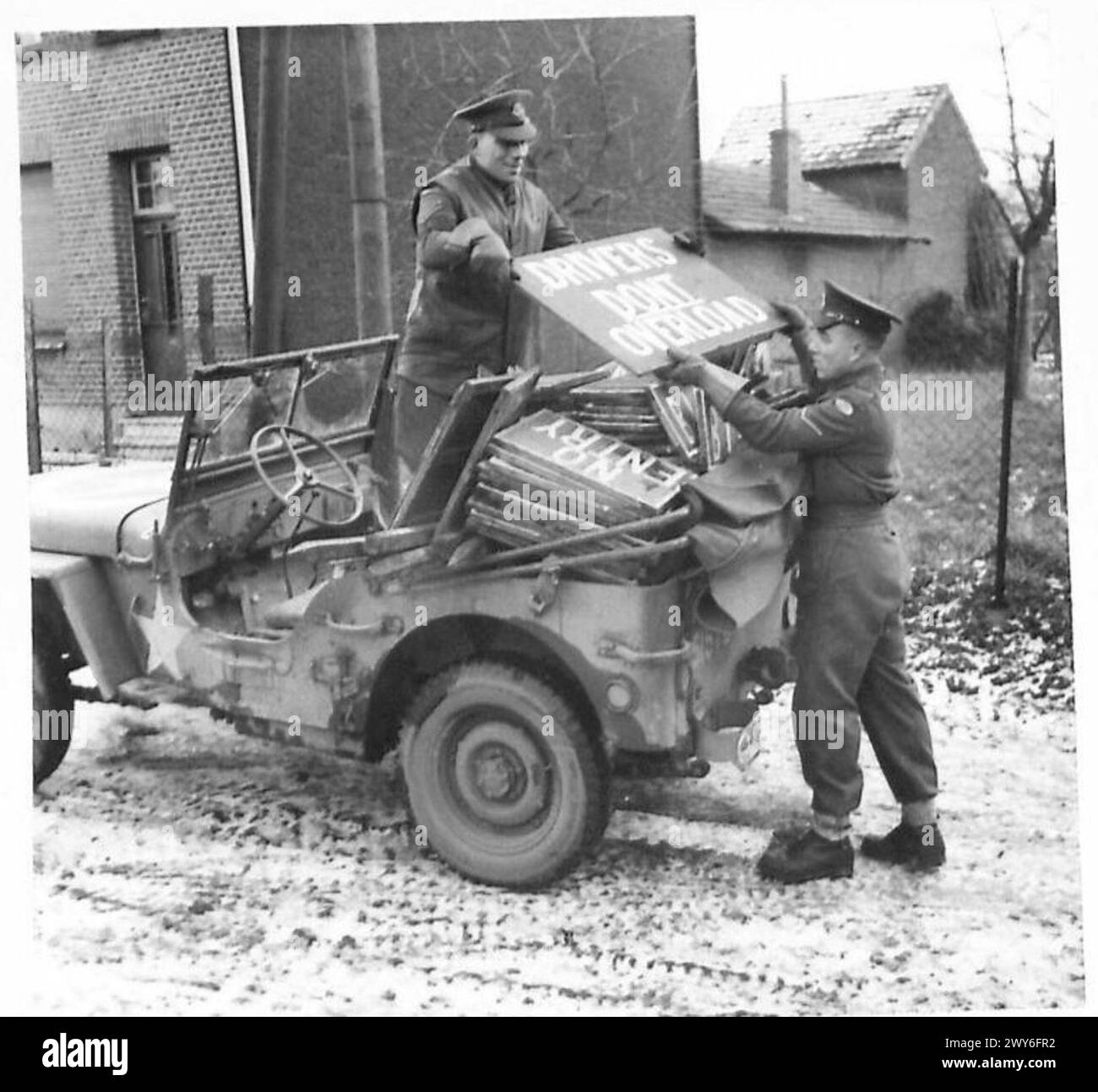 STEIN CORPS DELLA POLIZIA MILITARE AL LAVORO - Cpl Rinaldi (a sinistra) e L/Cpl Collyer caricano la loro Jeep con i cartelli prima di uscire per "firmare una strada". Notare la sezione "driver - non sovraccaricare". CPL J. Rinaldi: Sposato. Vive al 12 di Currie Road, Tunbridge Wells, Kent. Impiegato di banca prima della guerra. Si arruolò nell'esercito nel marzo 1940 e arrivò in Francia il D/15. Hobby - calcio e cricket. L/Cpl C. Collyer: Sposato. Vive al 155 di Peperharrow Road, Godaiming, Surrey. Prima della guerra, un macellaio. Si arruolò nell'esercito nel giugno 1940 e sbarcò in Francia, D/15. Hobby - falegnameria. , British Army, 21st Army Group Foto Stock