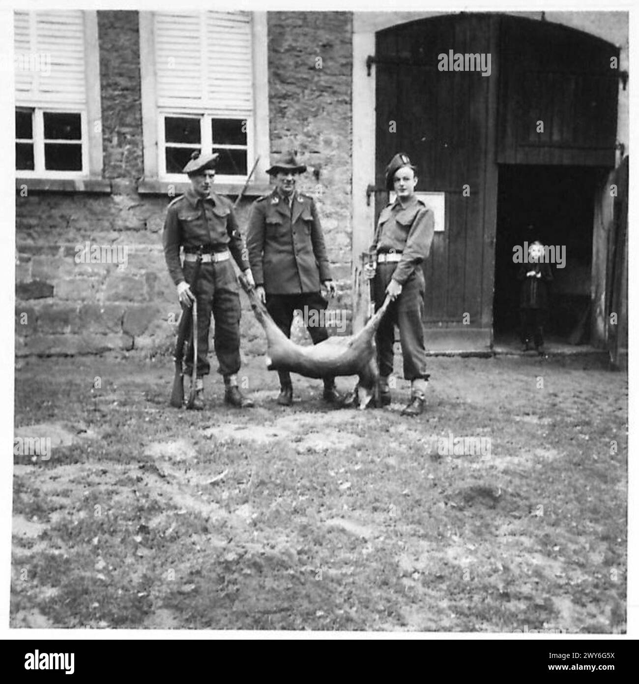 I corsari Raine e Webberley tengono un cervo a cui hanno sparato, con un guardiacaccia tedesco al centro, durante le operazioni dell'esercito britannico del Reno che forniscono carne ai tedeschi. Foto Stock