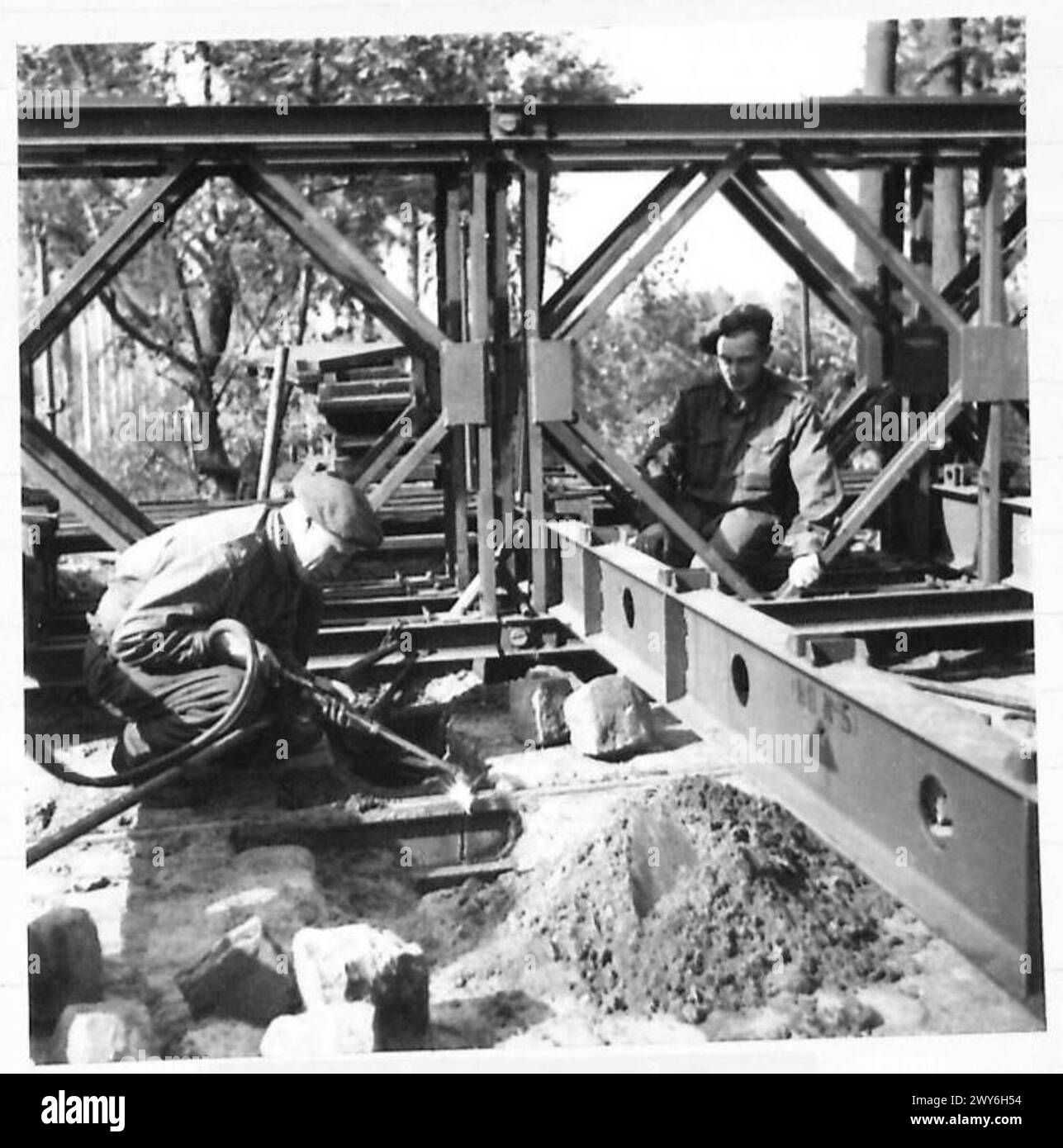 PONTE: 49 DIV. 1° CORPS B.L.A. - il tagliatore per ossiacetilene taglia le vecchie guide della tramvia che si trovano sulla strada del letto del ponte. , British Army, 21st Army Group Foto Stock