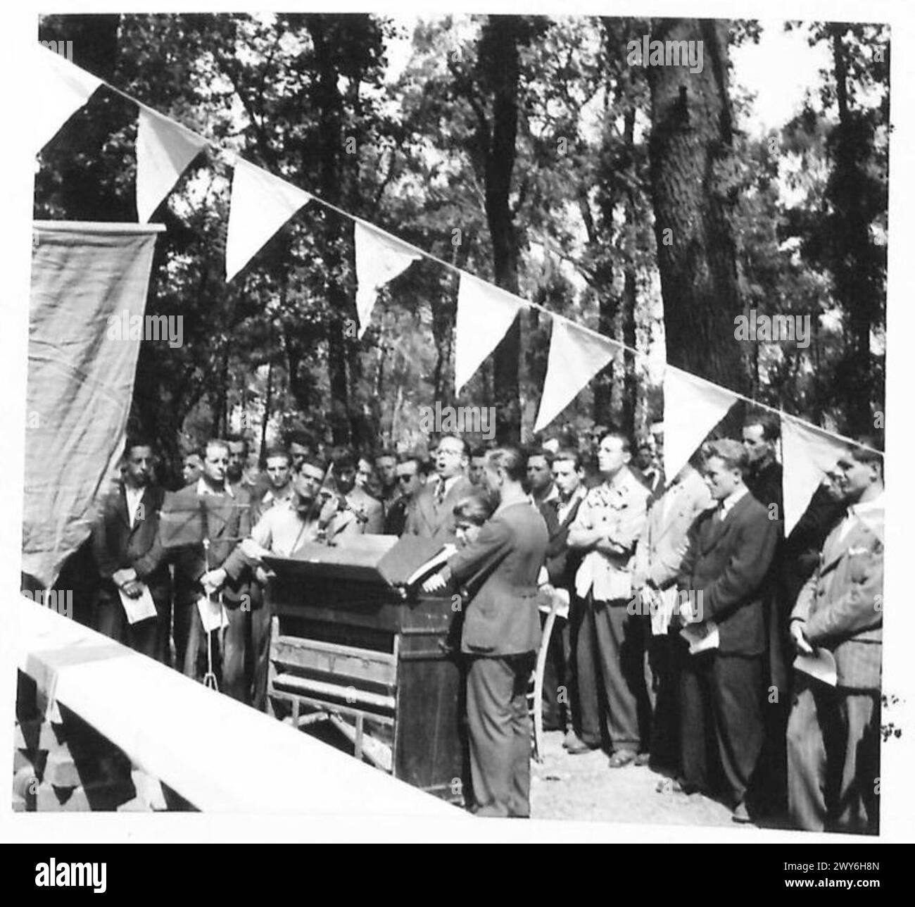 Gli sfollati italiani assistono a una cerimonia accompagnata da un coro e un'orchestra. Foto Stock