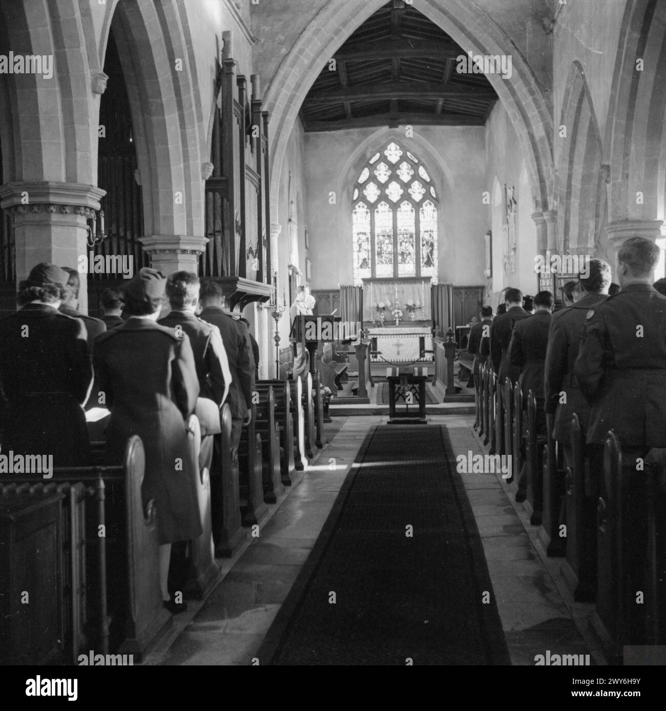 IL GIORNO DEL RINGRAZIAMENTO SI SVOLGE NELLA CHIESA DI CAMPAGNA INGLESE: AMERICANS IN CRANSLEY, NORTHAMPTONSHIRE, INGHILTERRA, Regno Unito, 23 NOVEMBRE 1944 - Una vista presa giù dalla navata della chiesa di Cransley, Northamptonshire, guardando verso l'altare, mostrando uomini dell'US Army Air Corps che prendono parte al servizio del Ringraziamento. , Foto Stock