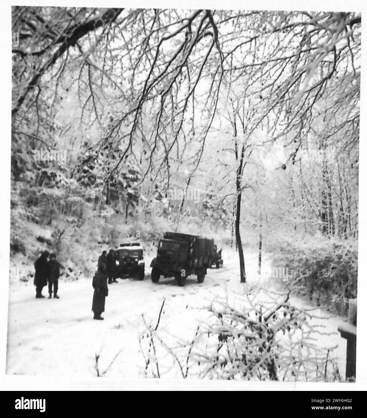 Un convoglio dell'esercito britannico si muove lungo strade innevate sul fronte occidentale durante le operazioni sotto il 21st Army Group. Foto Stock