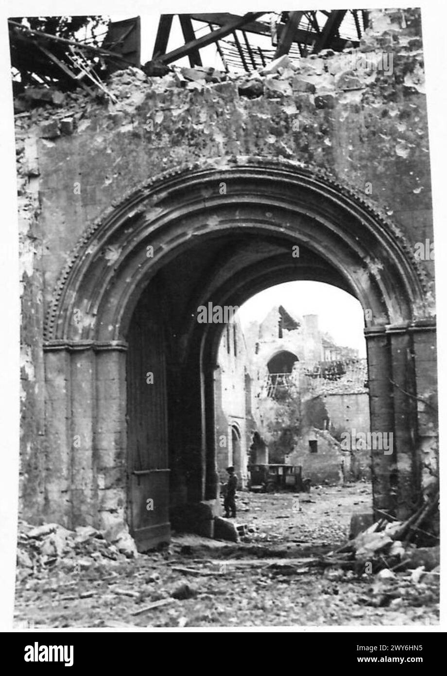 Vista attraverso le rovine della porta Ovest dell'Abbazia di Ardenne dalla strada principale, come documentato dall'esercito britannico, 21st Army Group. Foto Stock