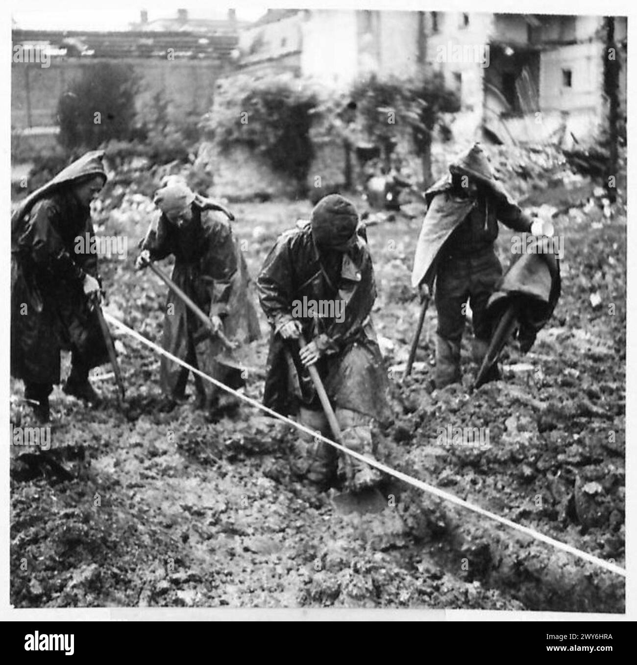 I pionieri che lavorano nei fossati vicino alla Senna indossano saccheggi per proteggersi dalle forti piogge sotto la supervisione del 21st Army Group. Foto Stock