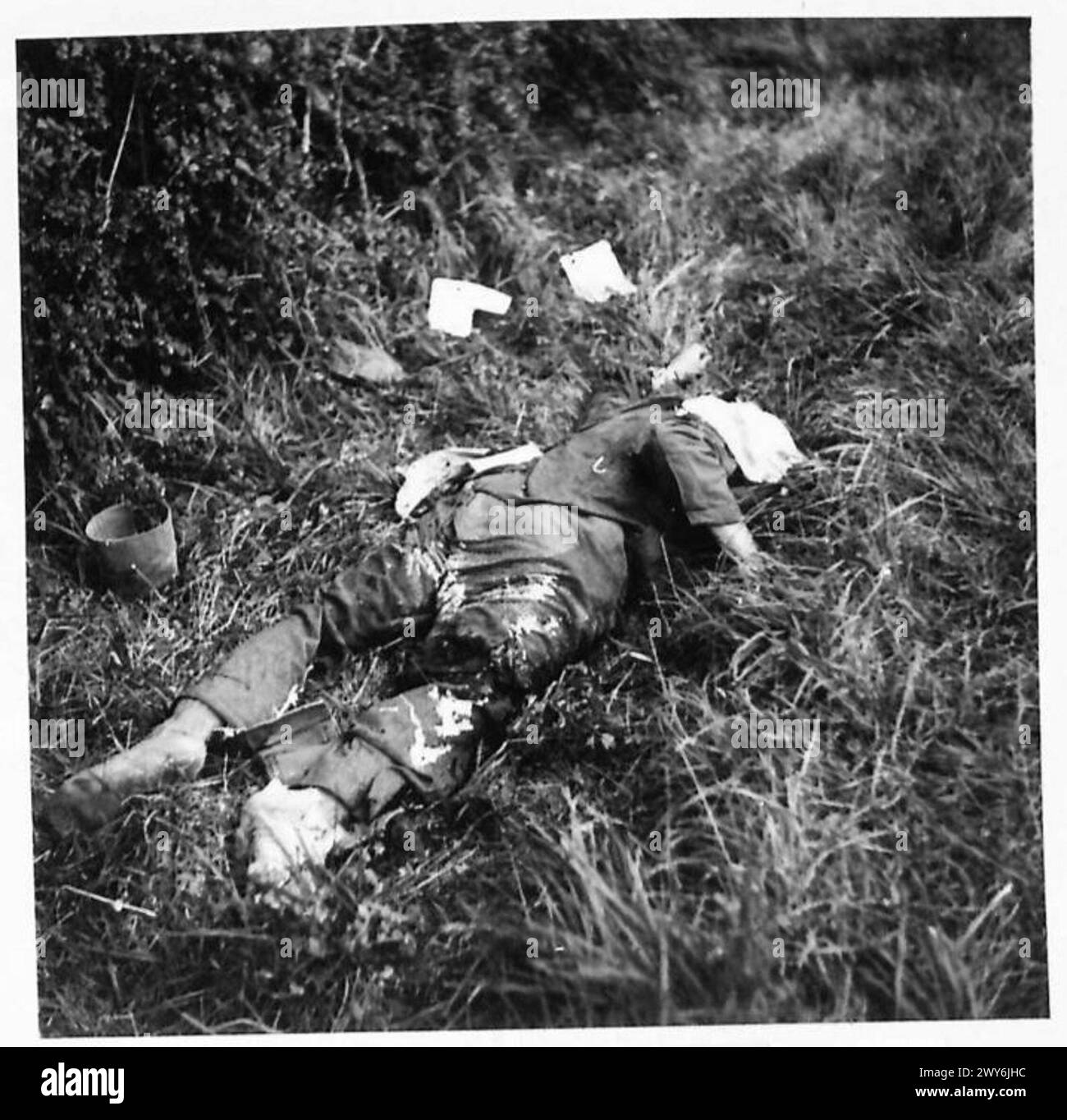 Durante la liberazione di Quillebeuf, un soldato tedesco defunto viene osservato sul campo di battaglia dalle forze alleate. Foto Stock