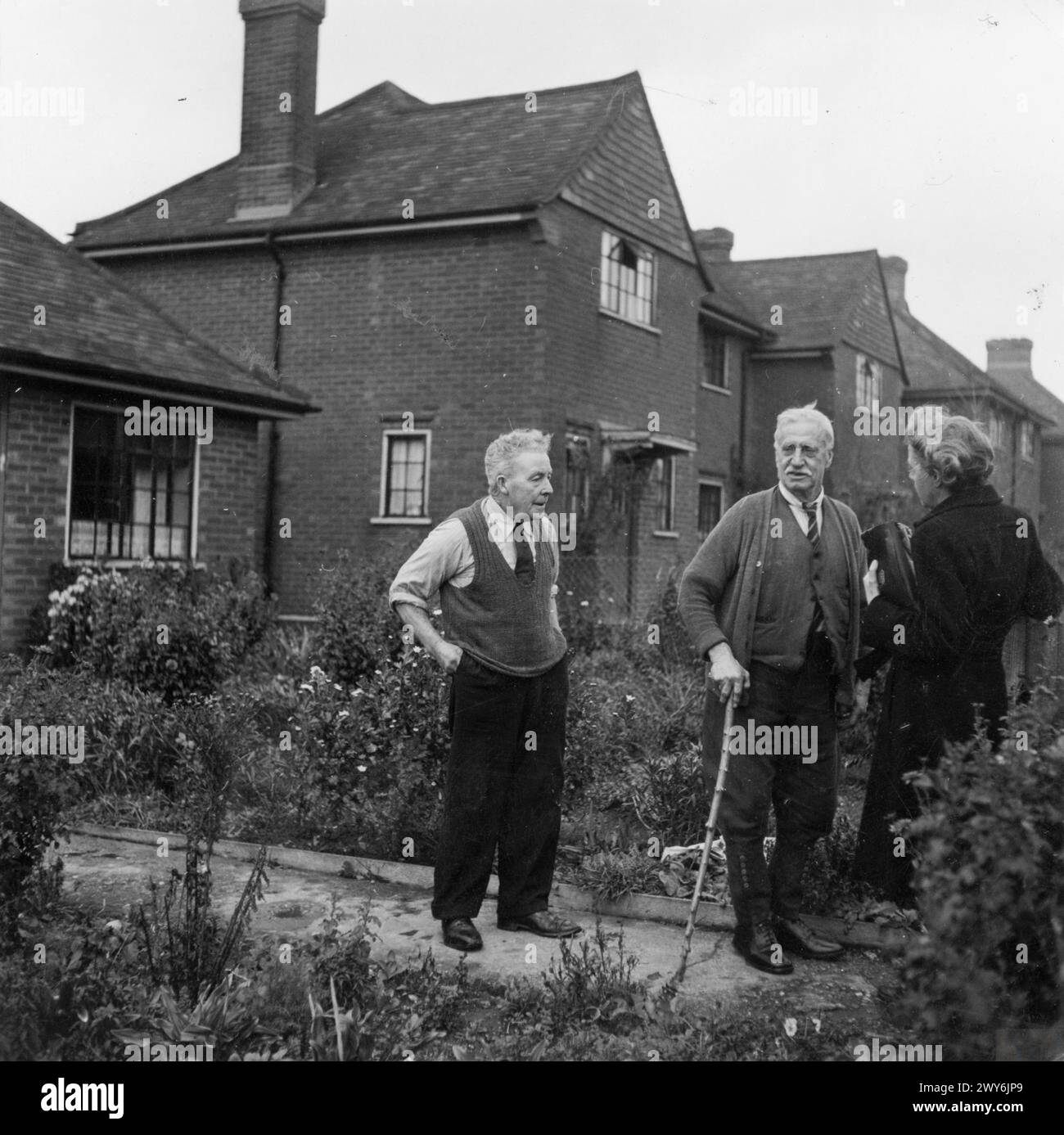 Sig.ra R, Welfare Officer for High Wycombe Rural District Council, in visita ai residenti anziani nei cottage del consiglio per pensionati a High Wycombe, Buckinghamshire, Inghilterra, 1944. Foto Stock