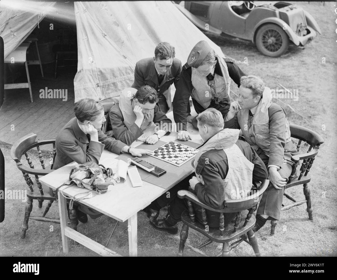 Piloti e cannonieri del No. 264 Squadron RAF giocano a draft fuori dalla loro tenda di dispersione a Kirton-in-Lindsey mentre erano pronti durante la Battaglia d'Inghilterra, agosto 1940. Foto Stock