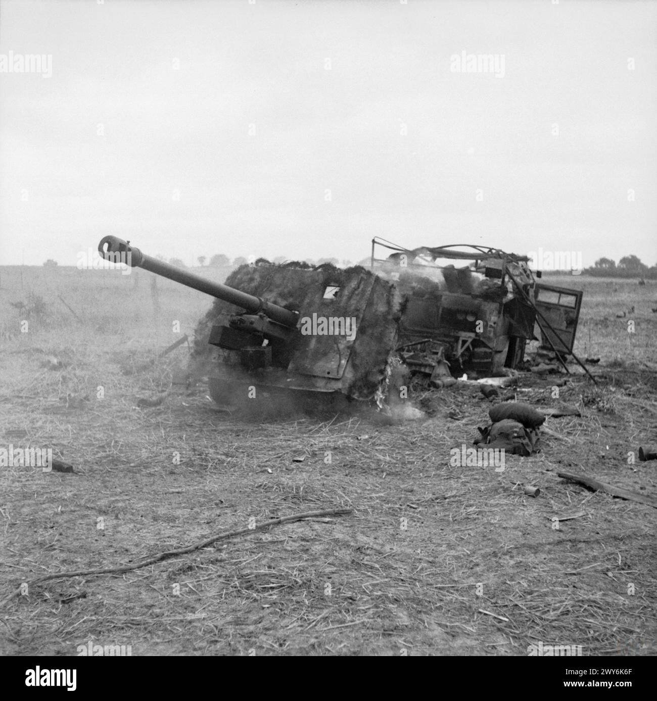 Un cannone anticarro da 17 libbre e un trattore d'artiglieria "Quad" bruciano sulla collina 112 dopo l'incendio di un mortaio il 15 luglio 1944 durante la campagna di Normandia dell'esercito britannico. Foto Stock