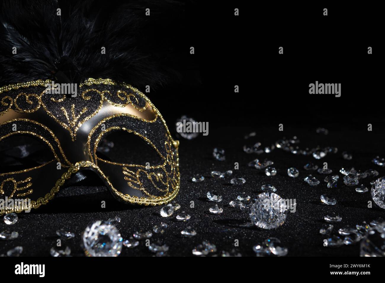 Vista ravvicinata della maschera d'oro Carnival con diamanti su sfondo nero. Foto Stock