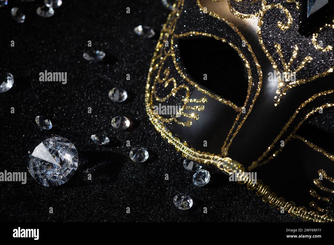 Vista ravvicinata della maschera d'oro Masquerade con pietre preziose su sfondo nero. Foto Stock