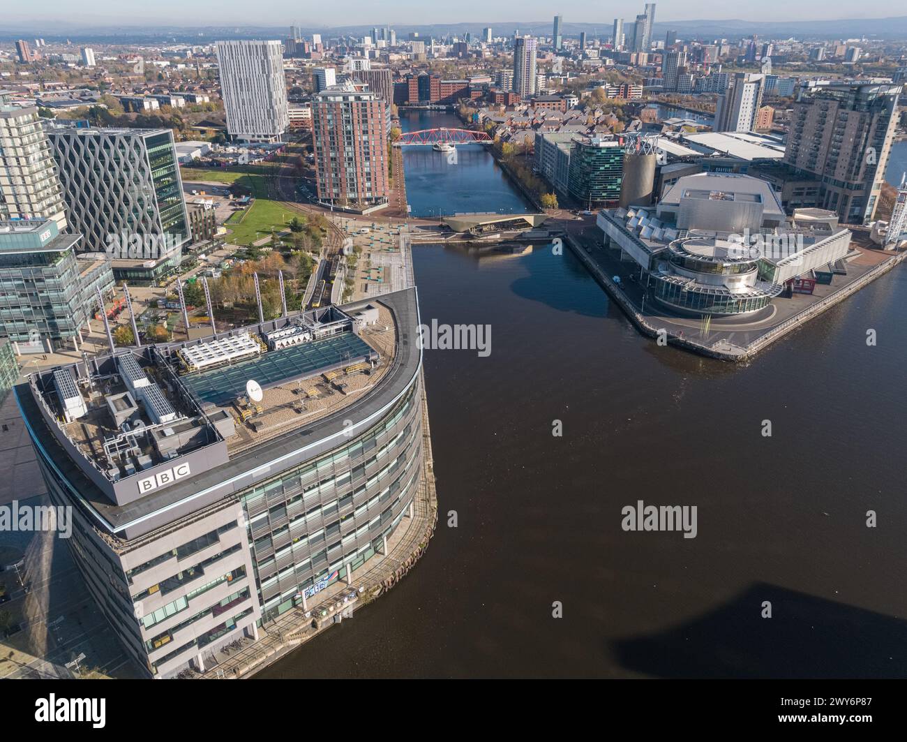 Foto con drone sul Manchester Ship Canal con Media City Footbridge e BBC Studios in primo piano e Media City e Salford Quays in lontananza Foto Stock