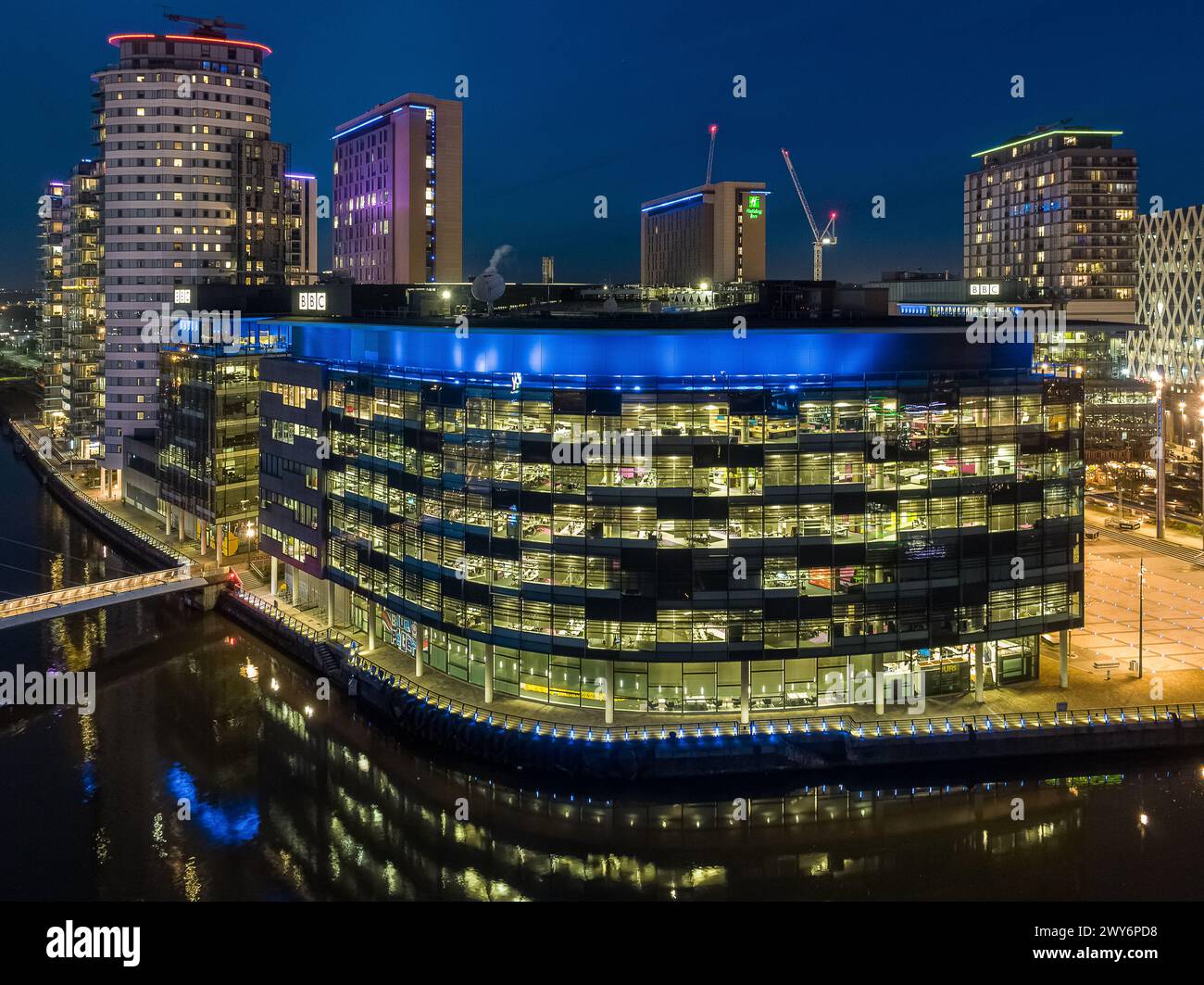 Fotografia notturna con drone dei BBC Studios a MediaCityUK, Salford Quays con Manchester Ship Canal in primo piano Foto Stock