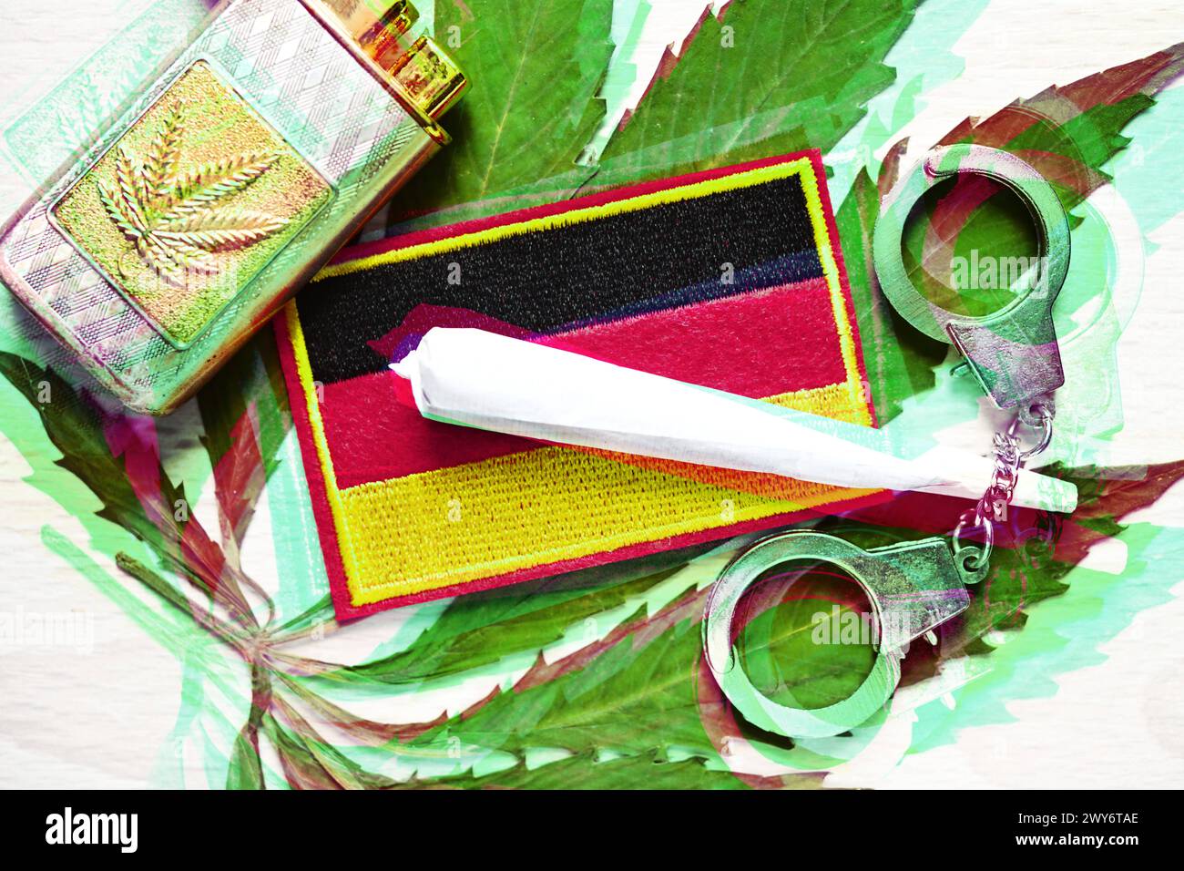 Joint und Deutschland-Fahne auf Cannabis-Blatt mit Handschellen, Cannabis-Legalisierung *** bandiera congiunta e Germania su foglia di cannabis con manette, legalizzazione della cannabis Foto Stock