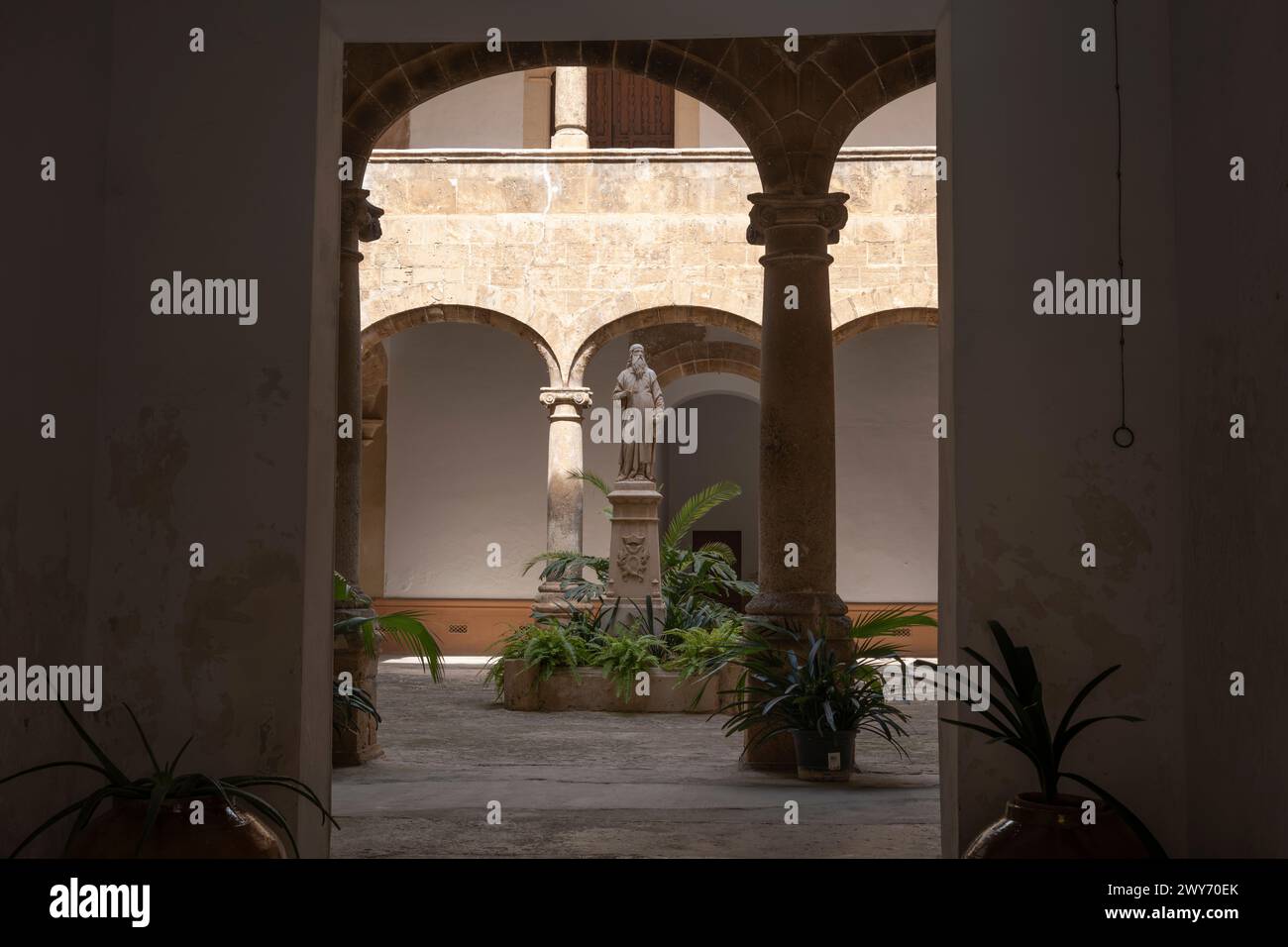 Un'antica scultura religiosa nel cortile dell'antico edificio storico di Palma di Maiorca, Spagna Foto Stock