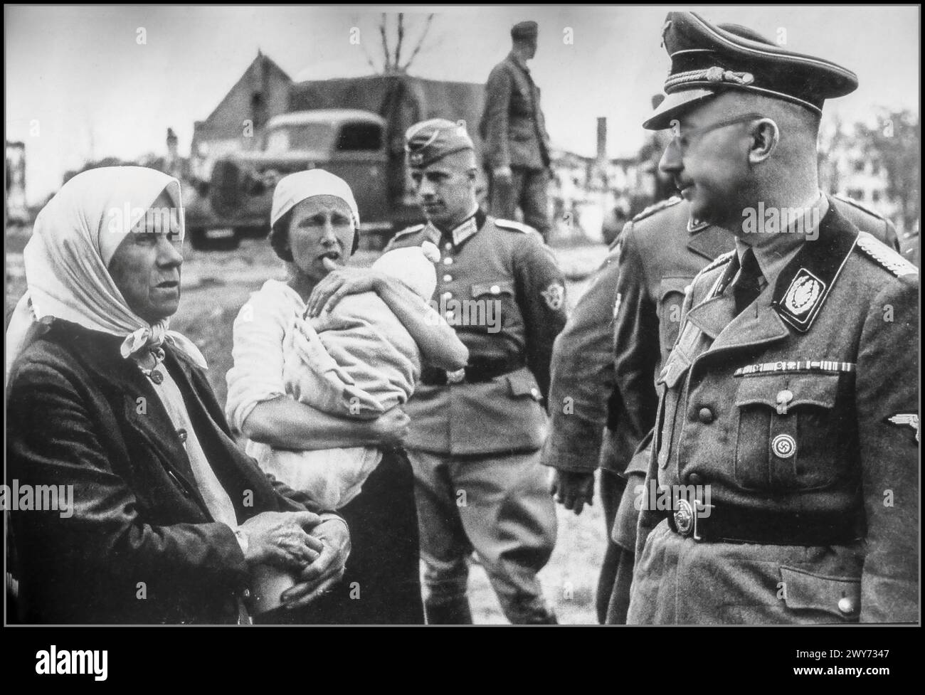 Seconda guerra mondiale Reichsführer, Heinrich Himmler parla con i contadini durante un tour di ispezione in Bielorussia. 1941 lo stato nazista-tedesco descrisse la guerra contro l'Unione Sovietica come una guerra razziale tra gli ariani tedeschi e gli slavi subumani ed ebrei. Fin dall'inizio la guerra contro l'Unione Sovietica includeva il trattamento brutale dei prigionieri di guerra sovietici da parte dei tedeschi, in violazione di ogni standard di guerra, e l'uccisione di prigionieri di guerra su vasta scala. Più di due milioni di persone sono state uccise in Bielorussia durante i tre anni di occupazione nazista, Foto Stock