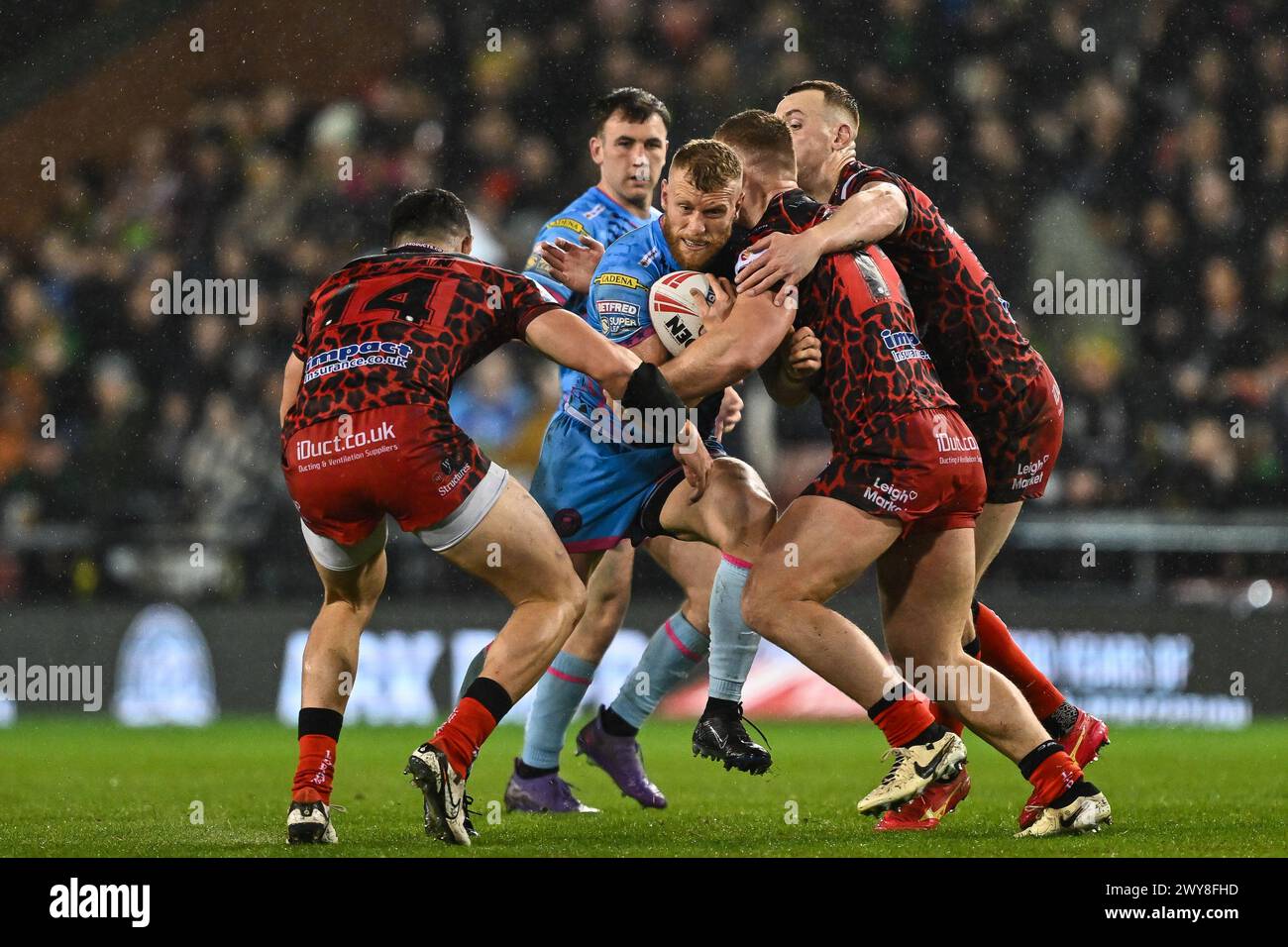 Luke Thompson dei Wigan Warriors viene affrontato da Jack Hughes dei Leigh Leopards e Dan Norman dei Leigh Leopards durante il Betfred Super League Round 7 Match Leigh Leopards vs Wigan Warriors al Leigh Sports Village, Leigh, Regno Unito, 4 aprile 2024 (foto di Craig Thomas/News Images) Foto Stock