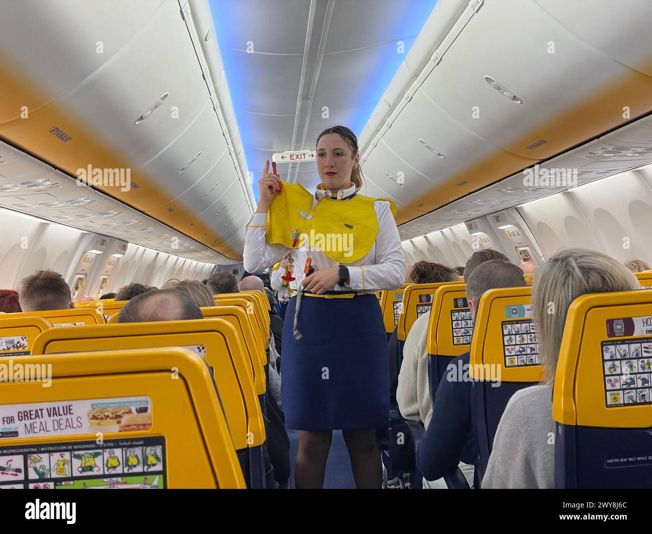 Assistente di volo che dimostra le procedure di evacuazione di emergenza a bordo di un volo Ryan Airlines. Foto Stock