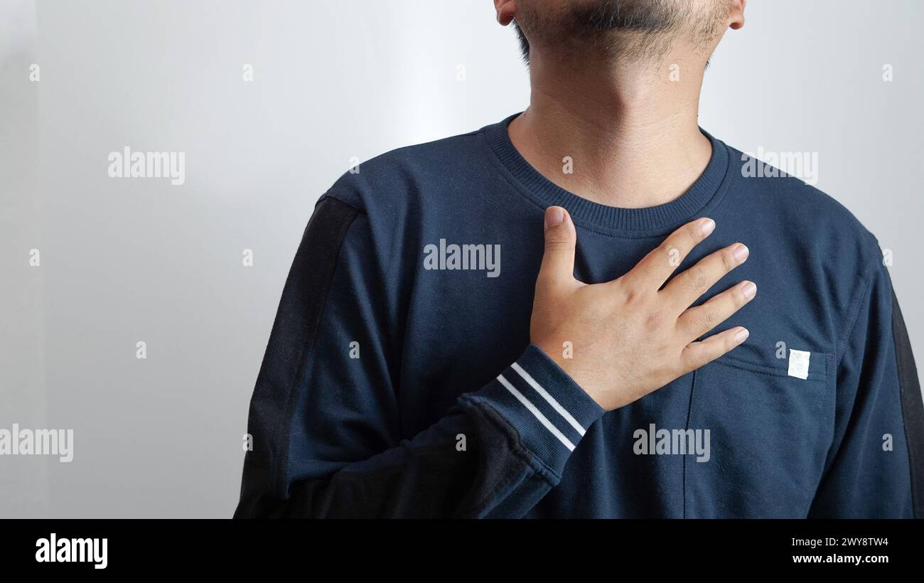 mal di gola, mani che tengono il collo che trattengono il mal di gola Foto Stock