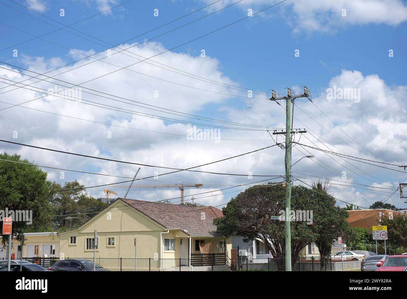 Palo elettrico in legno australiano con fili a bassa e alta tensione su una strada periferica nel sobborgo di Canley vale Western Sydney Foto Stock