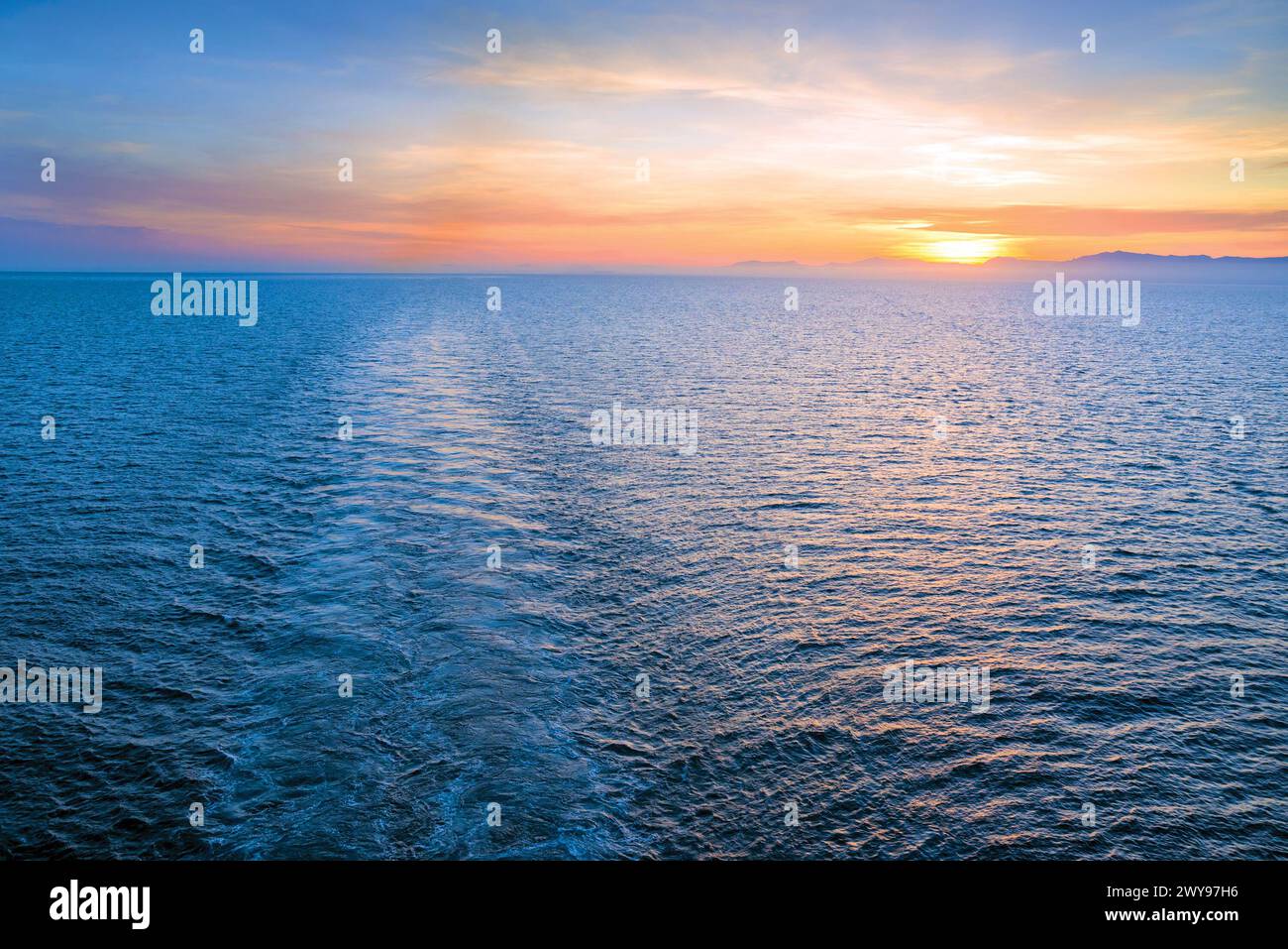 La sveglia della nave nel mare al tramonto Foto Stock